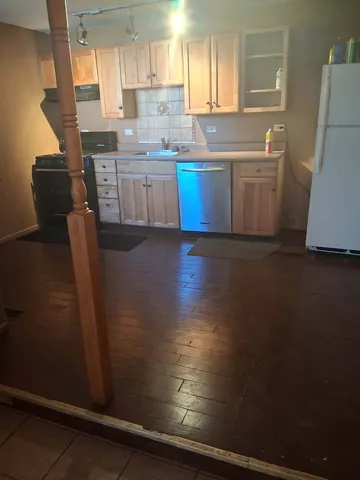 a kitchen with sink a microwave a refrigerator and cabinets