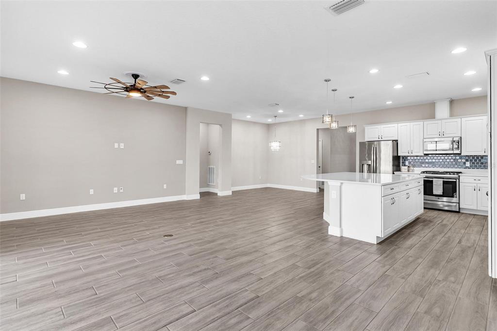 224 Silver Maple Road Groveland, FL 34736 - Photo 13 of 54 a view of kitchen with kitchen island stainless steel appliances cabinets and wooden floor