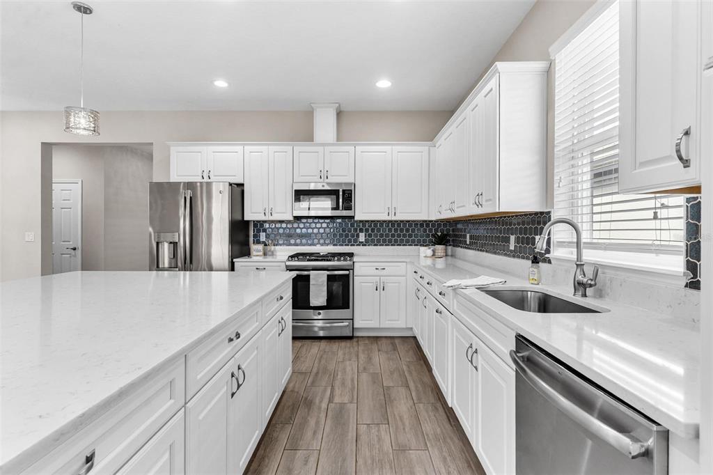 224 Silver Maple Road Groveland, FL 34736 - Photo 18 of 54 a large kitchen with kitchen island a sink a counter top space stainless steel appliances and cabinets