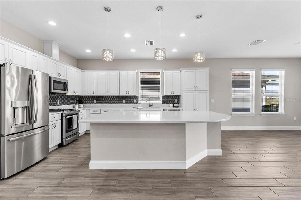 224 Silver Maple Road Groveland, FL 34736 - Photo 22 of 54 a large kitchen with cabinets counter top stainless steel appliances and cabinets