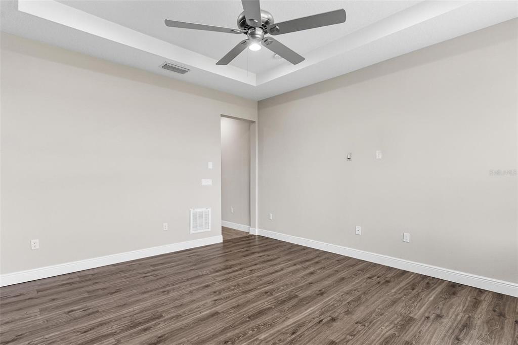224 Silver Maple Road Groveland, FL 34736 - Photo 27 of 54 an empty room with wooden floor and fan
