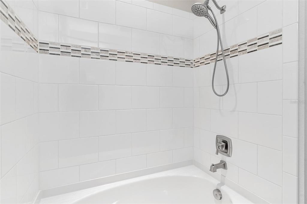 224 Silver Maple Road Groveland, FL 34736 - Photo 37 of 54 a bathroom with a bath tub with a shower