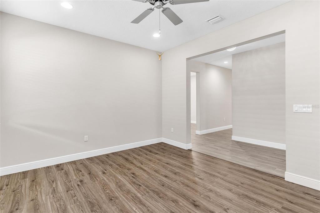 224 Silver Maple Road Groveland, FL 34736 - Photo 9 of 54 wooden floor in an empty room with a window