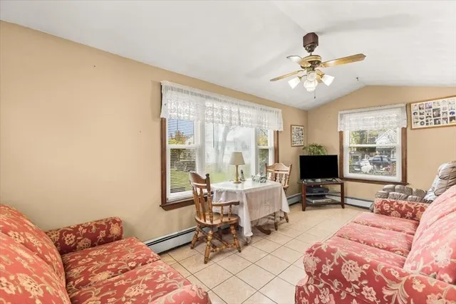 a living room with furniture ceiling fan and a window