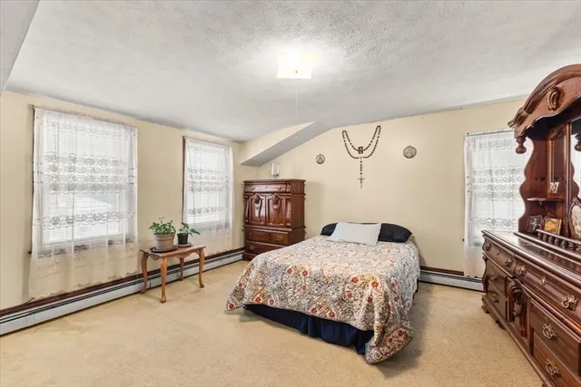 a bedroom with a bed couch and a window