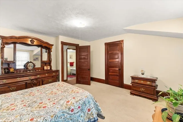 a bedroom with a bed and a dresser with mirror