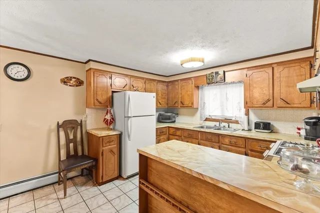 a kitchen with refrigerator a stove a washer dryer and cabinets