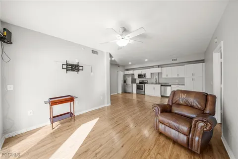 a living room with furniture and view of kitchen