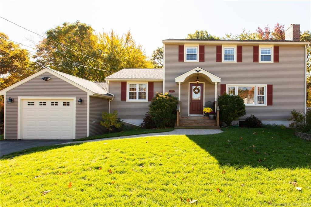 a front view of a house with a garden and yard