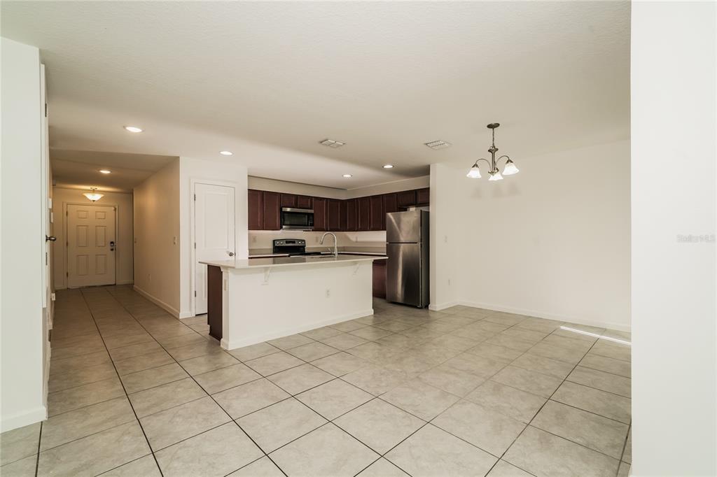 1473 Lucerne Loop Road Northeast Winter Haven, FL 33881 - Photo 7 of 25 a view of kitchen with stainless steel appliances kitchen island granite countertop a refrigerator and a stove top oven