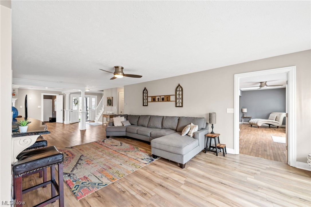 2425 McMackin Road Madison, OH 44057 - Photo 15 of 46 Living room featuring light hardwood / wood-style flooring, ceiling fan, and ornate columns
