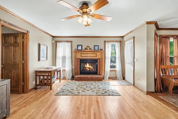 a view of a livingroom with a fireplace a chandelier and wooden floor