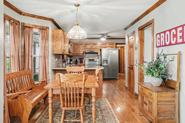a dining room with furniture a chandelier and wooden floor