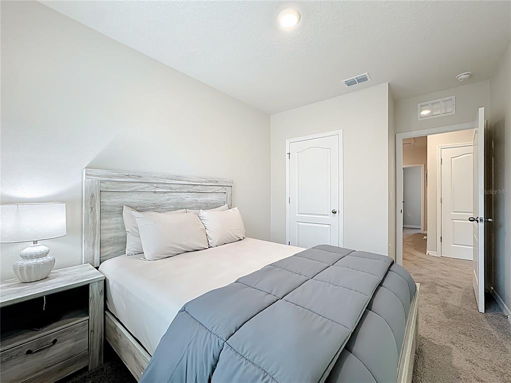 3140 Goose Road Davenport, FL 33837 - Photo 21 of 40 a bedroom with a bed and a lamp