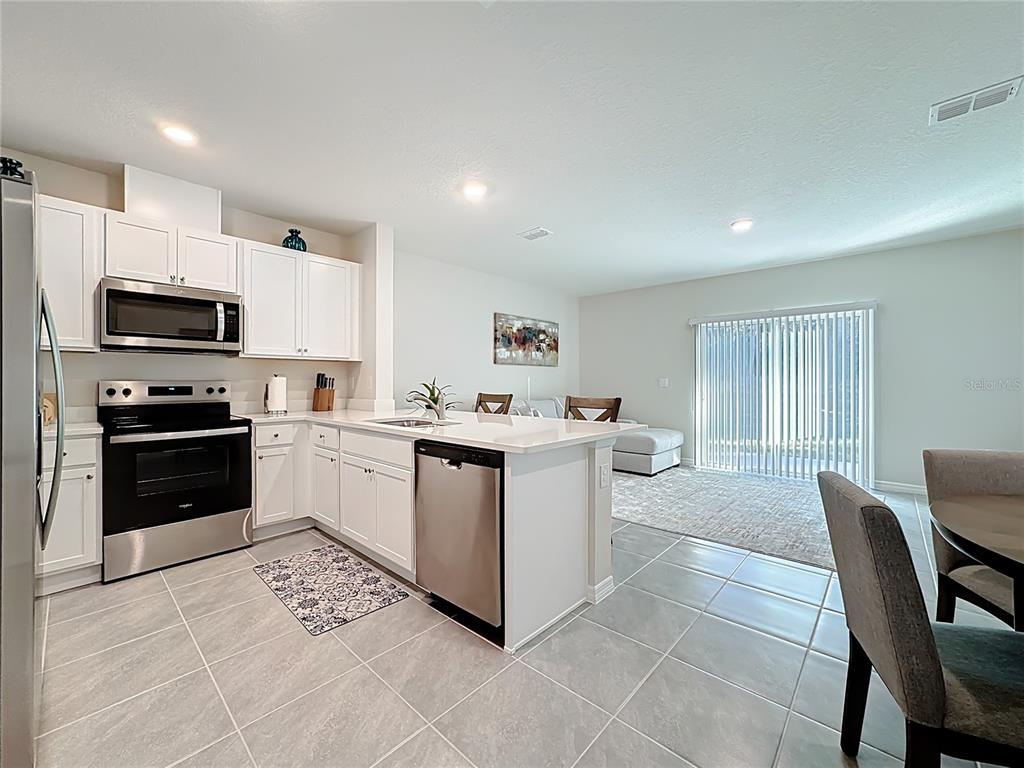 3140 Goose Road Davenport, FL 33837 - Photo 7 of 40 a kitchen with a cabinets and white appliances