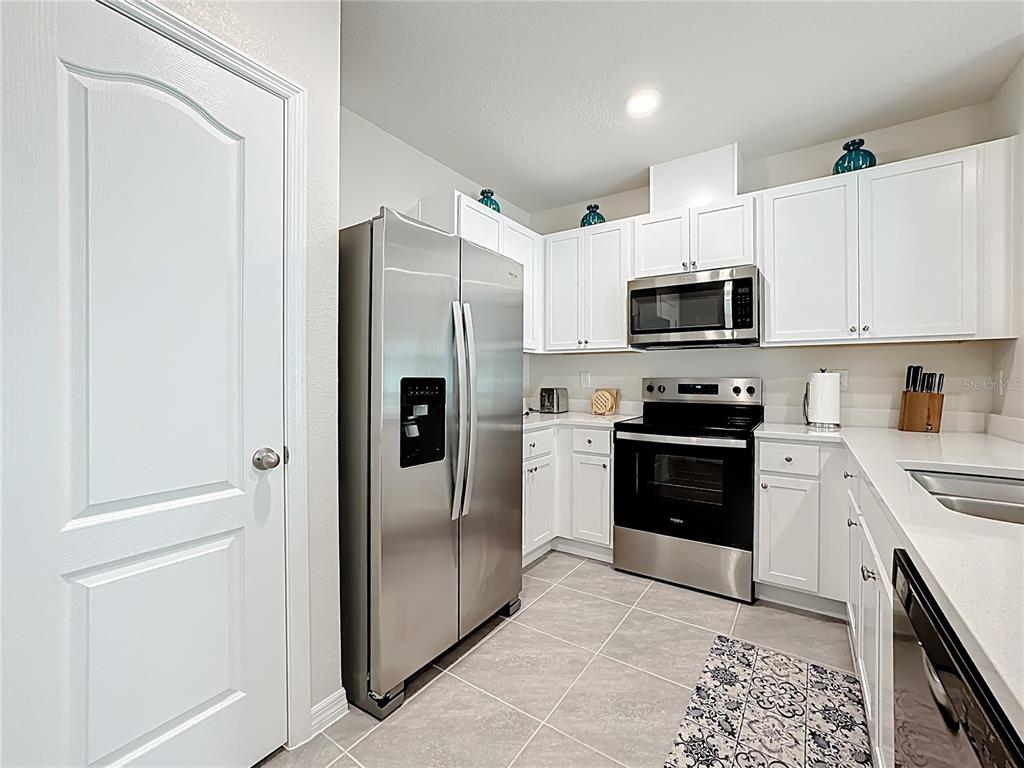 3140 Goose Road Davenport, FL 33837 - Photo 8 of 40 a kitchen with stainless steel appliances granite countertop a refrigerator stove and sink