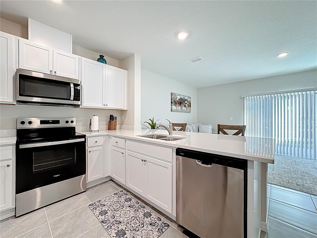 3140 Goose Road Davenport, FL 33837 - Photo 9 of 40 a kitchen with a sink stove and microwave