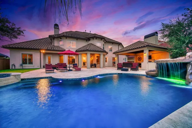 a view of a house with a swimming pool and sitting area