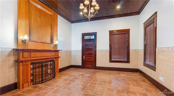 a view of an empty room with a fireplace and a window