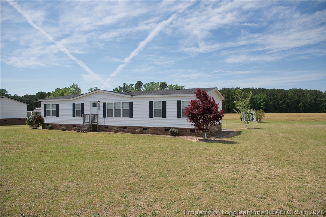 1071 Watts Road Lumberton, NC 28360 - Photo 2 of 31 a front view of a house with a yard table and chairs