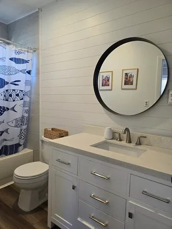 a bathroom with a toilet sink vanity and mirror