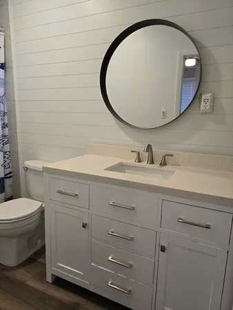 a bathroom with a toilet a sink and mirror