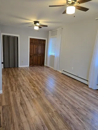 a view of an empty room with wooden floor