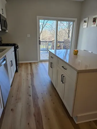 a view of a kitchen with wooden floor and a sink