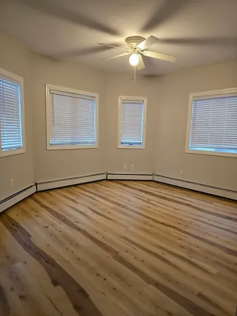 a view of a room with wooden floor and fan