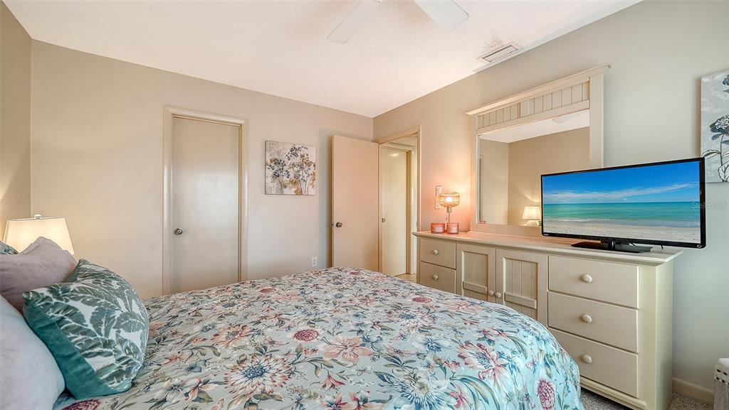 6204 Midnight Pass Road, Unit 205 Sarasota, FL 34242 - Photo 23 of 62 a bedroom with a bed and a flat screen tv