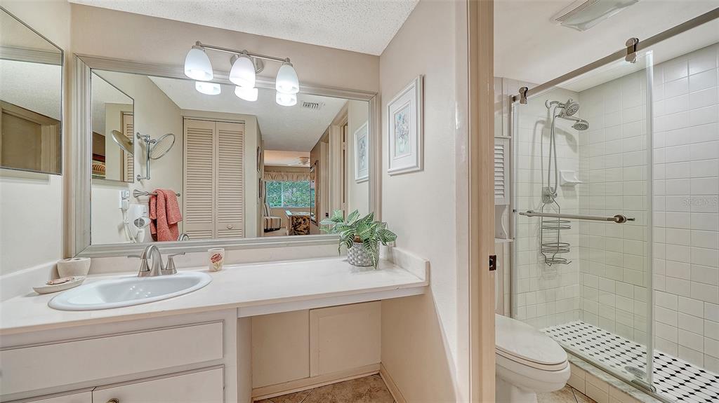 6204 Midnight Pass Road, Unit 205 Sarasota, FL 34242 - Photo 25 of 62 a bathroom with a sink a toilet and shower