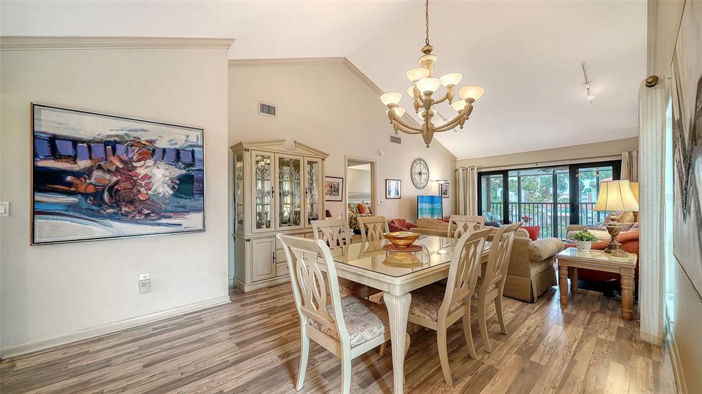 6204 Midnight Pass Road, Unit 205 Sarasota, FL 34242 - Photo 4 of 62 a view of a dining room with furniture wooden floor and chandelier