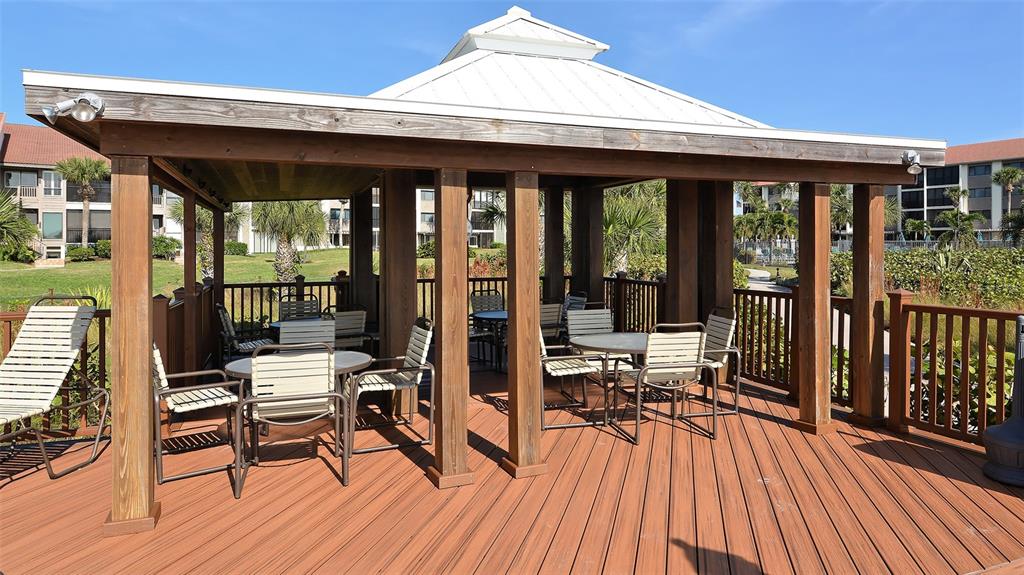 6204 Midnight Pass Road, Unit 205 Sarasota, FL 34242 - Photo 41 of 62 a view of a patio with table and chairs floor to ceiling window with wooden floor