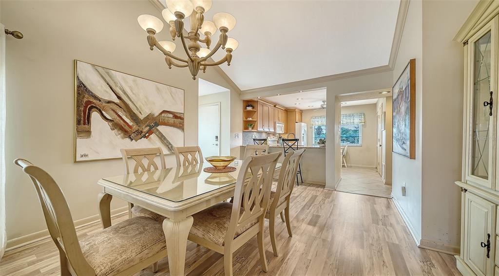 6204 Midnight Pass Road, Unit 205 Sarasota, FL 34242 - Photo 6 of 62 a view of a dining room with furniture wooden floor and a chandelier