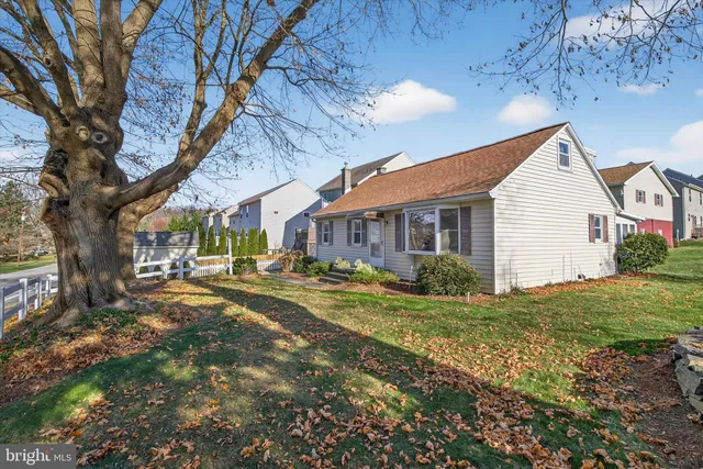 a view of a house with a large tree and a yard