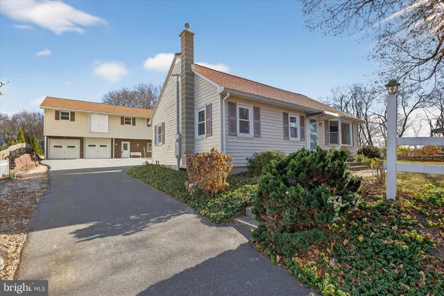 a front view of a house with a yard and trees