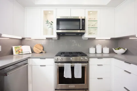 a kitchen with stainless steel appliances granite countertop a stove a microwave a sink and cabinets