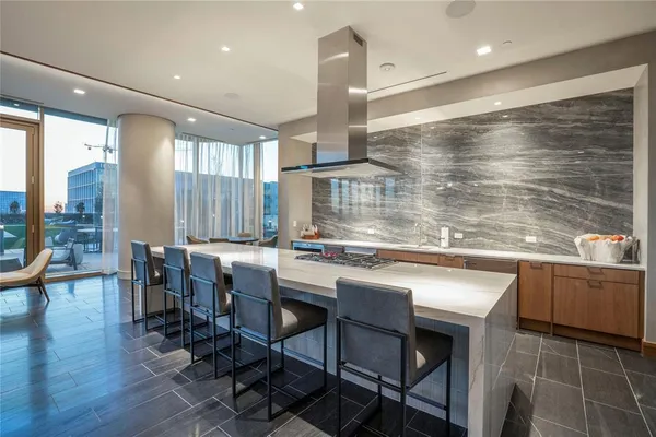 a kitchen with granite countertop a table chairs sink and wooden floor