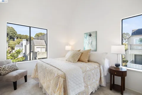 a bedroom with a bed and a lamp next to a window