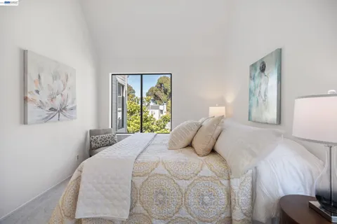 a bedroom with a bed and a painting on the wall
