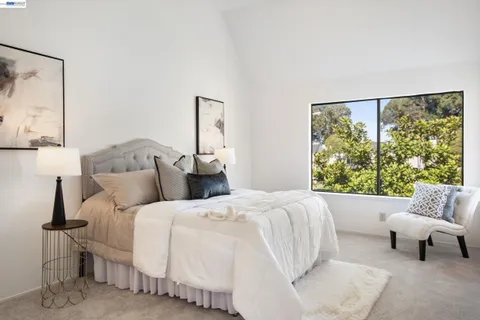 a bedroom with a bed and a couch next to a window