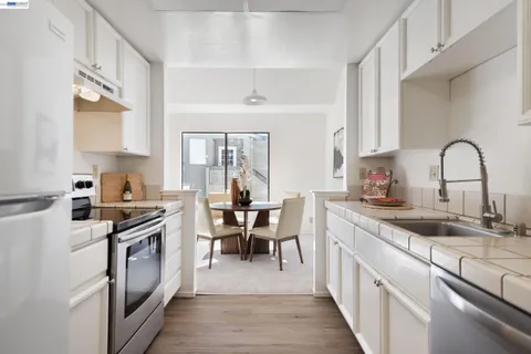 a kitchen with stainless steel appliances granite countertop a stove top oven a sink a counter space and cabinets
