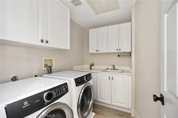 a bedroom with a bed a couch and a flat tv screen