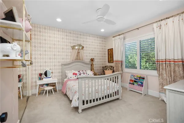 a spacious bedroom with a large bed and a chandelier