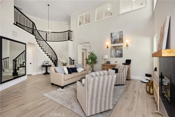 a living room with furniture floor to ceiling window and wooden floor