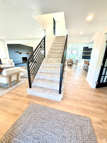 10158 High Point Lane Sandy, UT 84092 - Photo 8 of 24 Wood-finish flooring throughout, carpeted staircase with contemporary metal railings, and recessed ceiling lighting