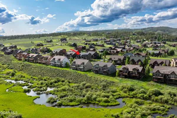 a large kitchen with stainless steel appliances granite countertop a stove top oven a sink dishwasher and a fireplace with wooden floor