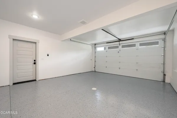 an empty room with cabinet and windows