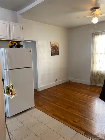 a view of a kitchen with wooden floor and a refrigerator