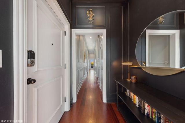 a view of a hallway with wooden floor and a mirror